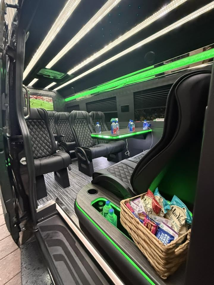 Passenger interior with black quilted seating, a table, and green accent lighting